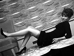 Elegant chick in black dress gets her rocks of posing in vintage lingerie on the desktop