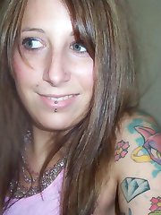 Tattooed and pierced babe spreads pussy