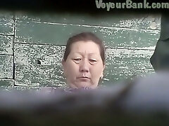 Wooly puss of a mature Asian lady in the public toilet room