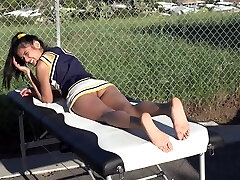 Cheerleader without underpants sunbathing on the massage table