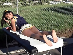 Cheerleader without panties sunbathing on the rubdown table