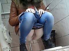 Slender girl in very tight blue jeans filmed in the restroom apartment
