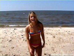 Hula hooping beauty on the beach in a colorful bikini
