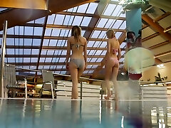 Two white young sexy girls dive in the pool and unclothe on cam