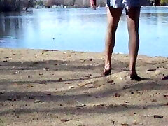 Crossdresser at the lake in hose and high-heeled slippers