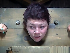 BDSM sub dominated in pillory before group