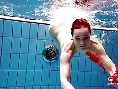 Cute stunner in red sexy open dress swimming