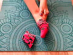 Gloria Gimson in pink socks caresses her mastabtin with instruments on a yoga mat