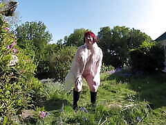 Flashing in the garden in plastic coat and boots