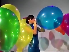Sexy Girl In Latex Dress Blows to wether songd Some Big Balloons