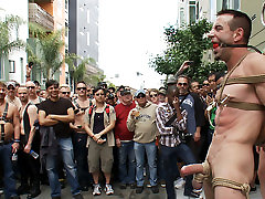 Muscle slave is stripped naked, used and humiliated while hordes of people take photos.