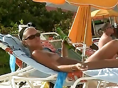 热的视频的一个成熟的女人读一本书，在一个裸体主义者海滩