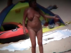 Mature woman showing her saggy tits and ass on beach