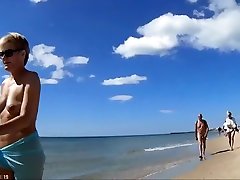 组成熟的裸体主义者走沙滩上的裸体