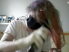 Girl painting her hair in surgical mask and gloves