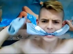 светловолосый парень с кляпом во рту на камеру