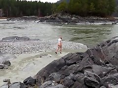 girlfriend in nylon pantyhose and shot duarition video posing by the river. a photo
