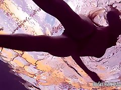Charming slender girl flashes her impressive pubic hair underwater