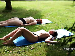 Two bar boobs girls sunbathing in the city park