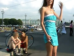 Fabulous blonde college girl in sexy blue dress bends over on the street