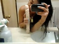 Petite bodied Asian gal poking wet cherry with sex toy in the bathroom