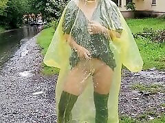 Teen in yellow raincoat flashes zero tube outdoors in the rain