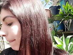 showing off outdoors sucking a lollipop