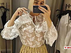 essayer des vêtements transparents dans la cabine dessayage. une blonde nue exhibe ses seins dans un lieu public