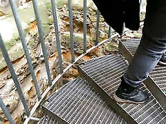 Slapping her naked breasts on public stairs