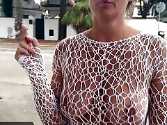 alicia raucht in der öffentlichkeit eine zigarette in einem durchsichtigen kleid