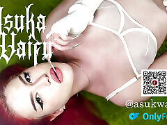 By candlelight, a red-haired, tattooed beauty enjoys herself