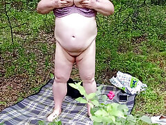 une voisine se déshabille dans un parc et se masturbe la chatte