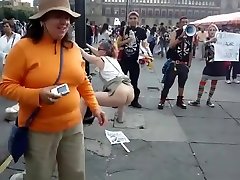 Female agitator pees and poops on a poster at a rally in protest to the government