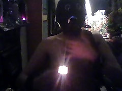 hooded slave plays with candles