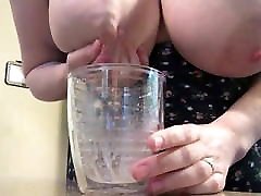 Big tits filling cup with milk