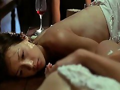 Maggie Q making out with a guy in the ocean and removing