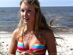 Hula hooping hottie on the beach in a colorful bikini