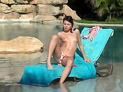 Pretty brunette chick masturbating while sunbathing