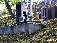 Blonde chick climbs on the concrete wall and urinates