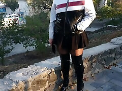 मालकिन नेटली में ऊँची एड़ी के काले पेटेंट चमड़े के जूते के बाहर पार्क में
